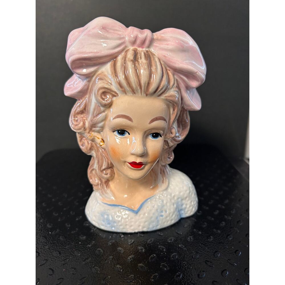 ceramic head vase features a detailed young lady with brown curls